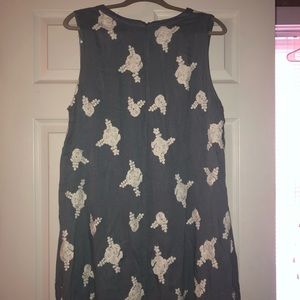 Sleeveless gray dress with white detailing.